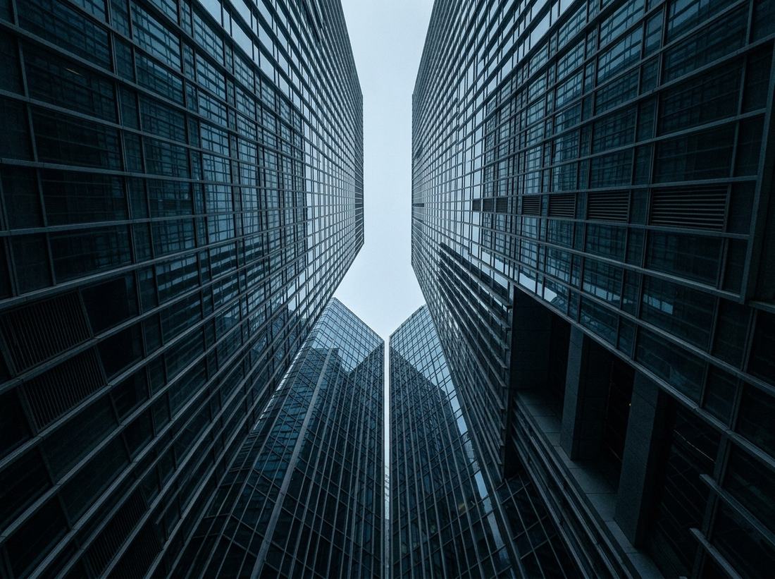 Glass office towers in Hong Kong Central seen from below, converging upward