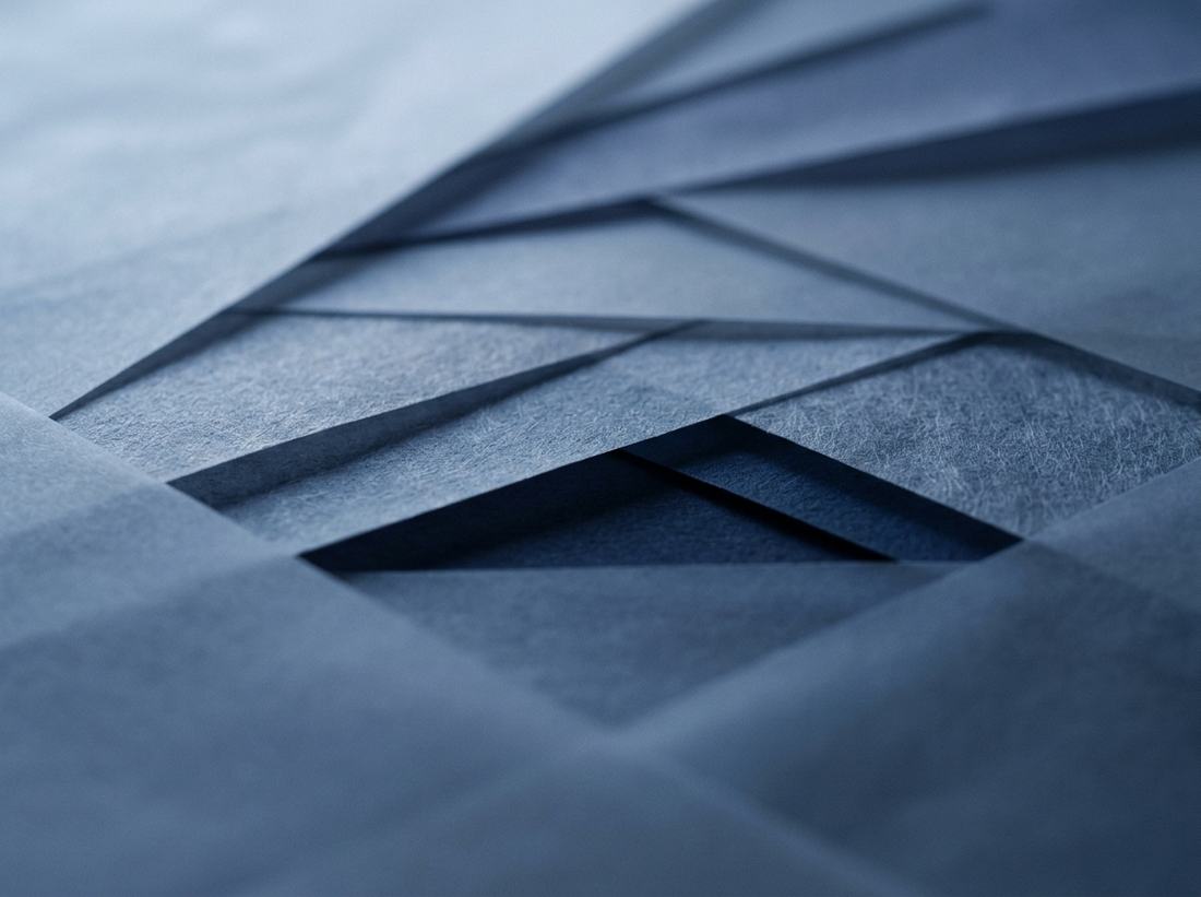 Overlapping translucent sheets of paper at shallow angles, casting soft shadows
